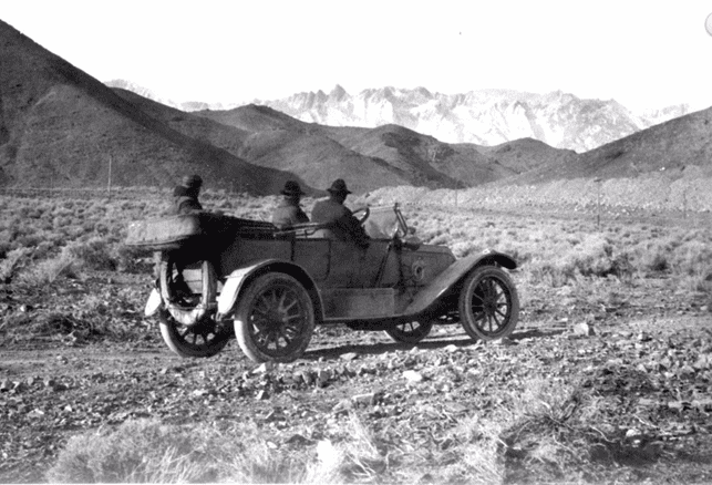 (ca. 1906)^^*โ View showing William Mulholland along with two others, sitting in a car in the Owens Valley. All three are looking toward the snow covered Eastern Sierras, water source of the yet to be built L.A. Aqueduct.